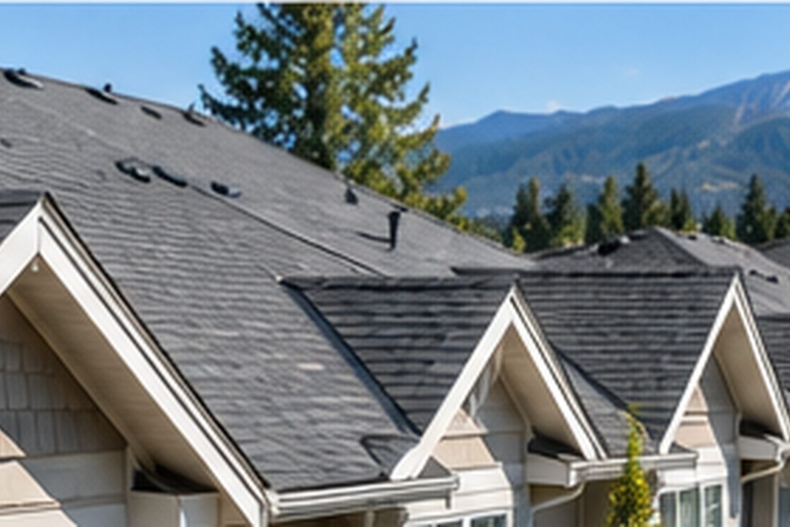 Townhouse community with shared roofs, mountains in the distance